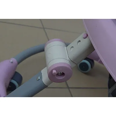 Une marchette musicale rose et blanche, faite de pièces en plastique et en métal. Le mot 