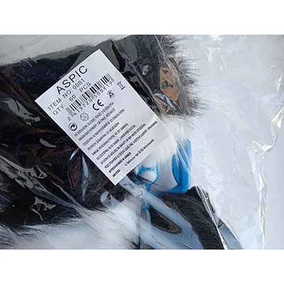 Un chien noir et blanc sur une laisse en plastique bleu. Le jouet a une tête douce et farcie et un corps dur. Il a un collier avec une cloche en métal sur le cou, et un boîtier de batterie avec trois piles AA 1,5 V.