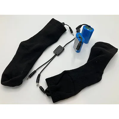 Une paire de chaussettes noires serrées, équipées d'une électronique encombrante alimentée par batterie au lithium.