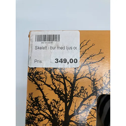 Produit de décoration d'Halloween à piles avec un squelette dans une cage. Le produit a des fonctions de son, de lumière et de mouvement.