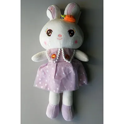 Lapin blanc en peluche dans une robe violette, avec un accessoire en forme de carotte. Le jouet a une ventouse attachée à sa tête avec une ficelle. Taille de 40 cm.