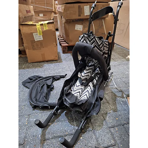 Une poussette pliable avec un motif en zigzag noir et blanc.