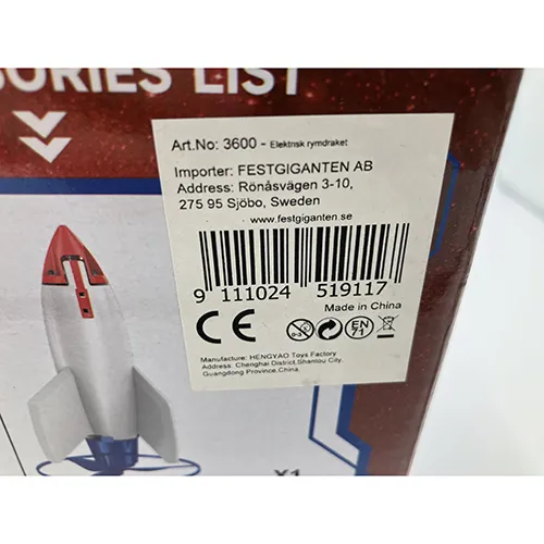 Fusée jouet en mousse blanche, d'environ 30 cm de hauteur, équipée d'une base d'hélice en plastique rouge alimentée par un câble USB comprenant une télécommande et une rampe de lancement bleue.