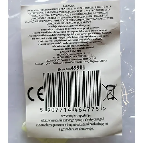 Poupée en plastique dans une robe textile violette. Les pattes de la poupée sont placées dans une boule en plastique transparent avec des plumes. Un contrôleur, y compris une batterie, est fixé à la tête de la poupée.