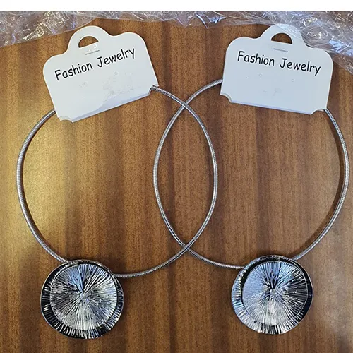 Collier rond en métal avec un pendentif en métal en forme de deux cercles connectés de couleur argentée.