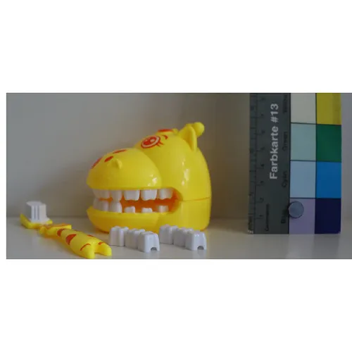 Ensemble de brosses à dents composé d’une tête de girafe (jaune) avec mâchoire articulée et de deux «couronnes à dents» sur lesquelles accrocher les brosses à dents. Produit vendu en ligne, notamment via Amazon (ASIN: B0DPJCLKBL).