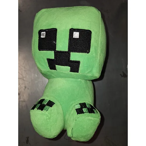 Jouet en peluche, dans un design vert inspiré de Minecraft. Produit vendu en ligne, notamment via AliExpress.