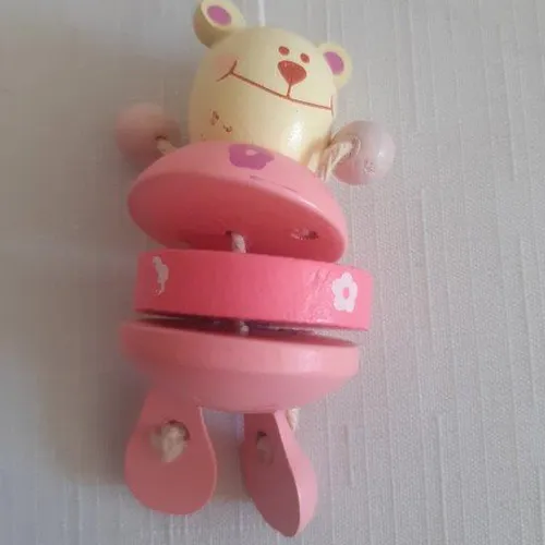 Jouet de berceau rose en bois avec cinq figures d'ours en peluche.