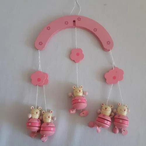 Jouet de berceau rose en bois avec cinq figures d'ours en peluche.