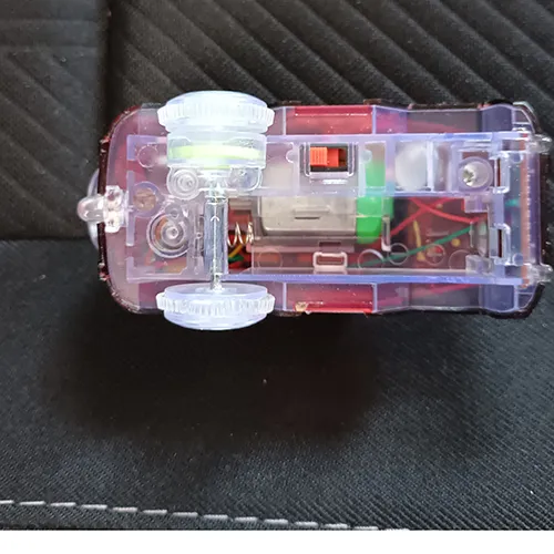 Jouet en plastique à piles en forme de voiture équipé d'une piste en plastique, de piles légères et de piles AA.