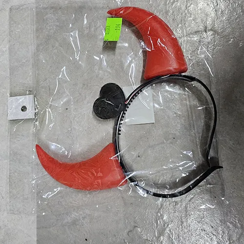 Bandeau en plastique brillant en forme de cornes de diable, à piles. Au milieu du bandeau se trouve un couvercle en forme de cœur pour deux piles AG13.