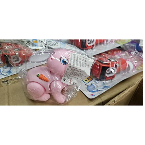 Jouet de lapin en plastique rose, avec un interrupteur. Le jouet avance, s'allume et produit de la musique lorsqu'il est allumé.