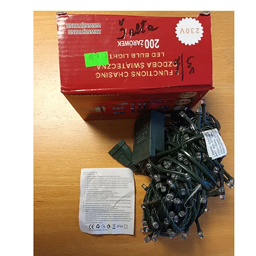 Chaîne d'éclairage composée de fils verts, de 200 ampoules LED blanches et d'un panneau de commande en plastique vert pour le réglage de 8 fonctions lumineuses différentes.