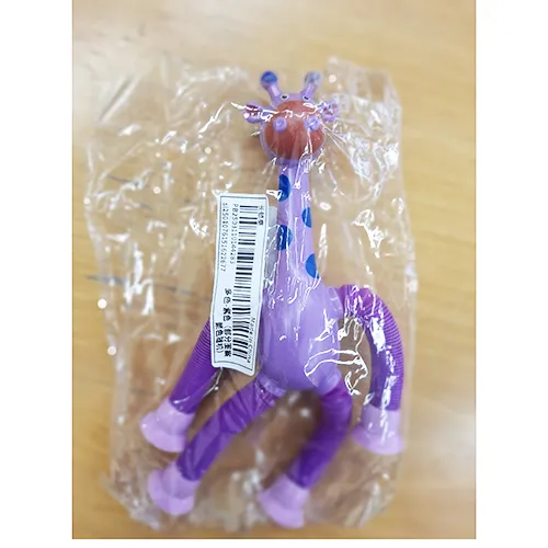 Jouet en plastique en forme de girafe en violet. Les pattes de la girafe peuvent être étendues, et il y a des ventouses aux extrémités des pattes qui peuvent être attachées à une fenêtre, des meubles, etc. Produit vendu en ligne, notamment via Shein (identifiant unique: sl2501076151622677)