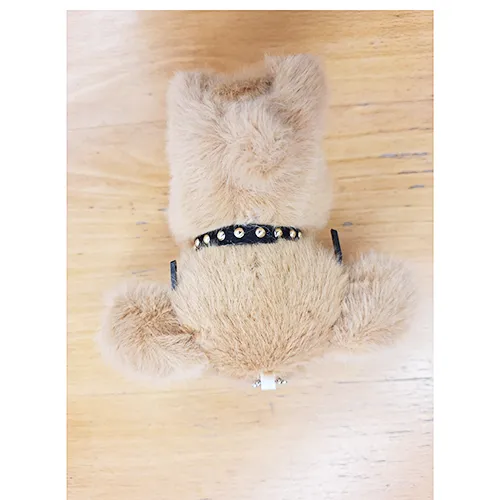 Jouet en peluche, en forme de chiot brun avec des lunettes noires et un collier avec une cloche. Produit vendu en ligne, notamment via Shein.