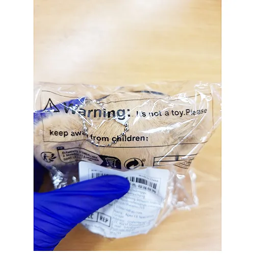 Jouet en peluche, en forme de chiot brun avec des lunettes noires et un collier avec une cloche. Produit vendu en ligne, notamment via Shein.