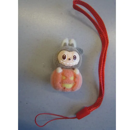 Jouet doux, en plastique et feutre, en forme de poupée Labubu. Le jouet comprend une sangle. Date de production: Juin 2025.