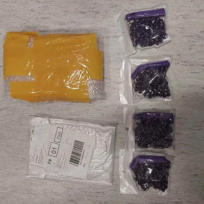 Collier de perles violettes avec un long pompon violet et des garnitures métalliques de couleur argentée. Produit vendu en ligne, notamment via AliExpress (identifiant unique: 1005003701979934).