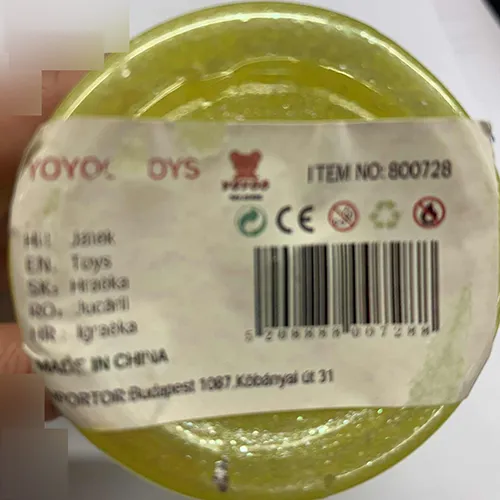 Jaune jouet slime emballé dans un récipient en plastique avec un couvercle vert décoré avec des oreilles et des motifs d'étoiles.