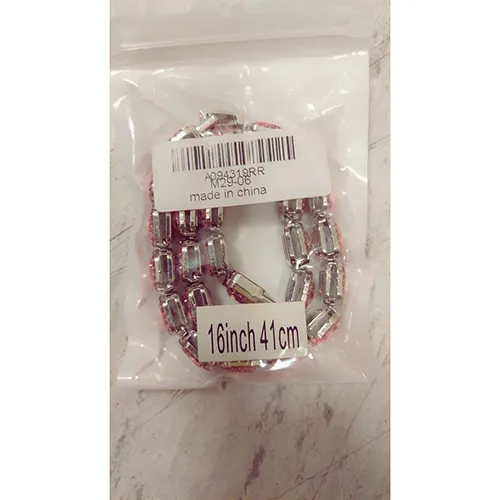 Collier en métal argenté avec pierres roses. Produit vendu en ligne, notamment via AliExpress.