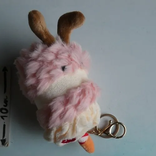 Porte-clés avec un jouet doux en forme de gâteau d'anniversaire avec des yeux en plastique et un fermoir en métal doré. Produit vendu en ligne, notamment via TikTok.