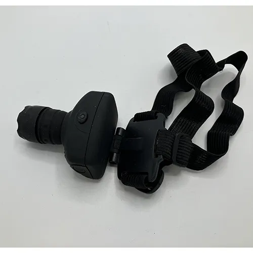 Lampe frontale en plastique dur noir avec une sangle textile. Produit vendu en ligne, notamment via Garderoben.se.