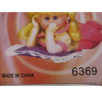 Poupée à piles avec des cheveux blonds attachés en deux queues de cheval avec des nœuds rouges, vêtue d'une robe rouge avec des pois.