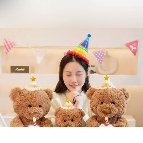 Jouet doux, en forme d'ours en peluche brun avec un chapeau d'anniversaire tenant un gâteau dans ses mains. Produit vendu en ligne, notamment via Shein.
