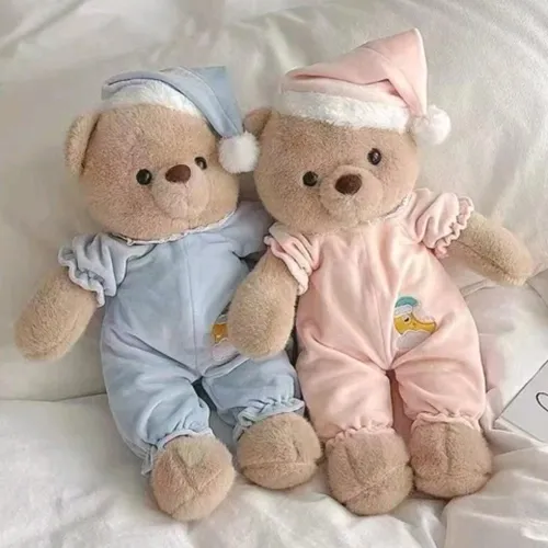 Jouet doux en forme d'ours aux yeux en plastique noir, vêtu d'un pyjama bleu et d'un bonnet de nuit assorti. Produit vendu en ligne, notamment via TikTok.