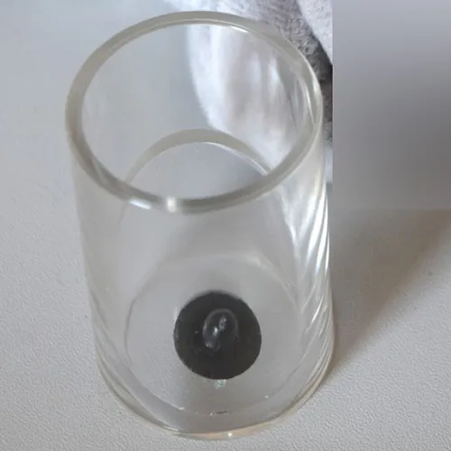 Figure en peluche grise en forme d'animal avec une couverture en peluche rose sur le ventre.