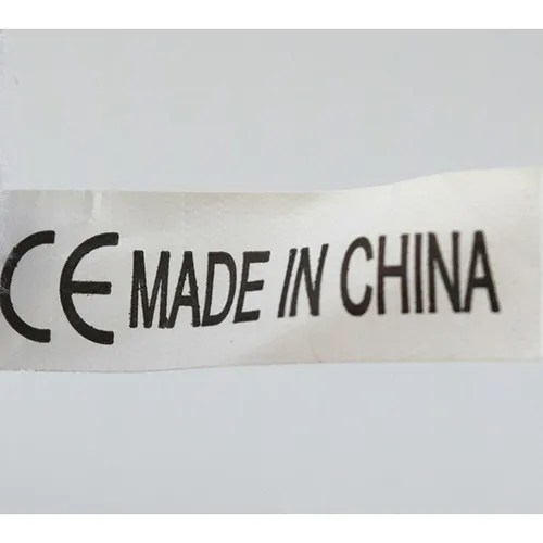 Figure en peluche grise en forme d'animal avec une couverture en peluche rose sur le ventre.