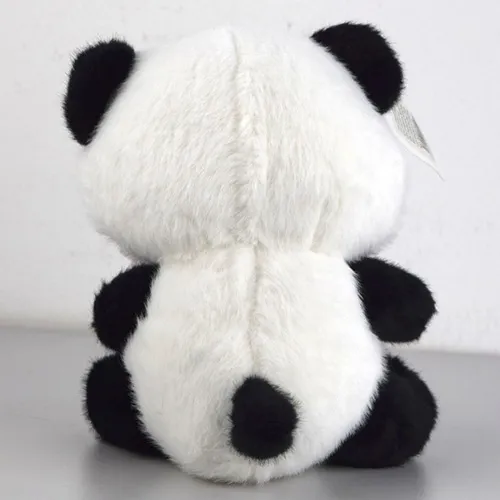 Jouet de panda en peluche noir et blanc avec un ruban rose autour du cou.