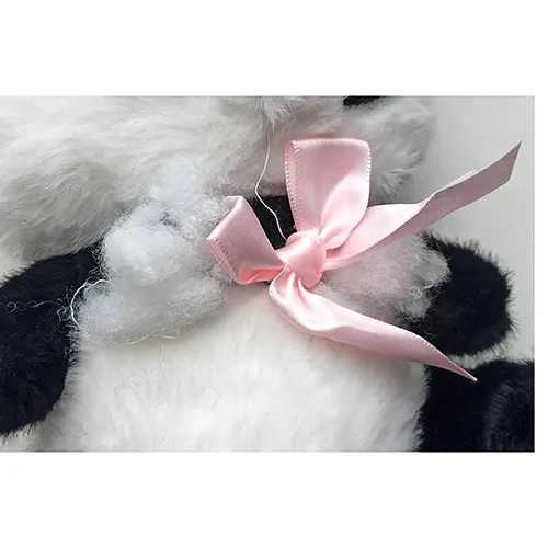 Jouet de panda en peluche noir et blanc avec un ruban rose autour du cou.