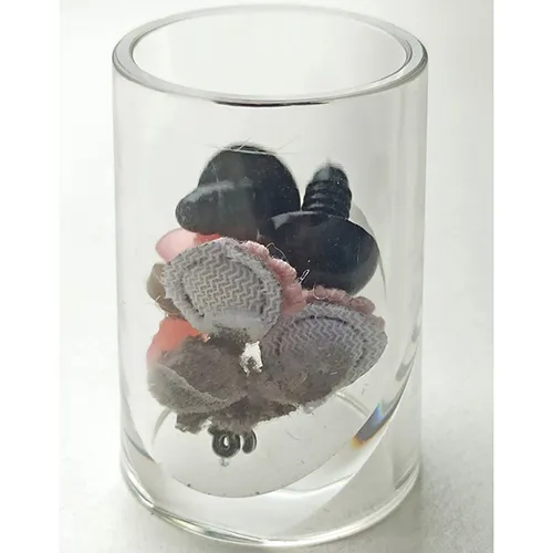 Jouet de panda en peluche noir et blanc avec un ruban rose autour du cou.