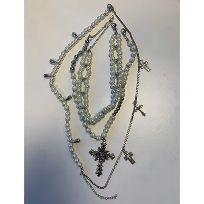 Collier en argent avec perles et croix. Produit vendu en ligne, notamment via Amazon.