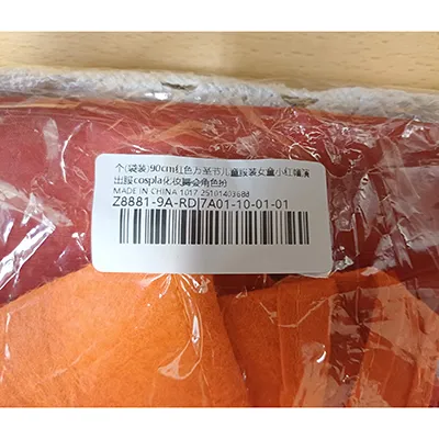 Costume fantaisiste de Little Red Riding Hood composé d'un bandeau rouge, d'un sac en forme de citrouille, d'un tablier blanc, d'une robe blanche, noire et rouge et d'une cape à capuche rouge. Produit vendu en ligne, notamment via TikTok.