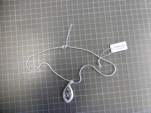 Collier en métal argenté avec pendentifs en métal argenté, noir et doré, fermeture et prolongateur de chaîne.