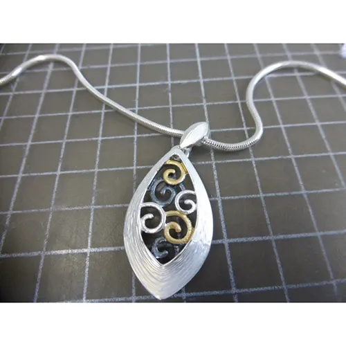 Collier en métal argenté avec pendentifs en métal argenté, noir et doré, fermeture et prolongateur de chaîne.