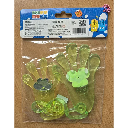Jouet en plastique, mains adhésives élastiques jaunes et vertes avec visages et cordes se terminant par des boucles.