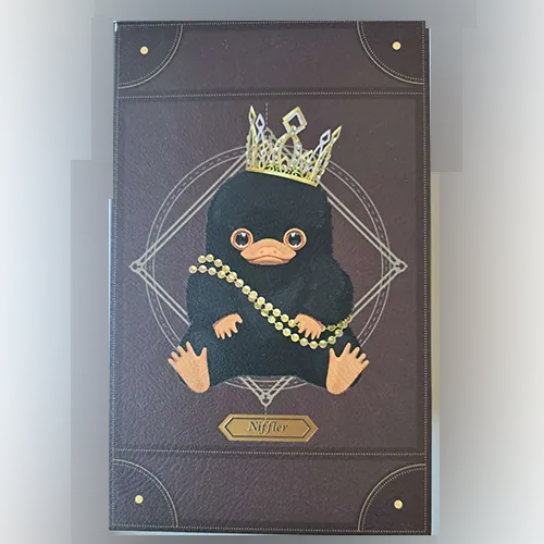 Jouet doux, en forme de créature Niffler, avec une couronne en or et un collier perlé. Produit vendu en ligne, notamment via Shein.