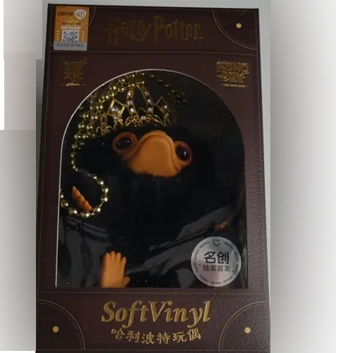 Jouet doux, en forme de créature Niffler, avec une couronne en or et un collier perlé. Produit vendu en ligne, notamment via Shein.