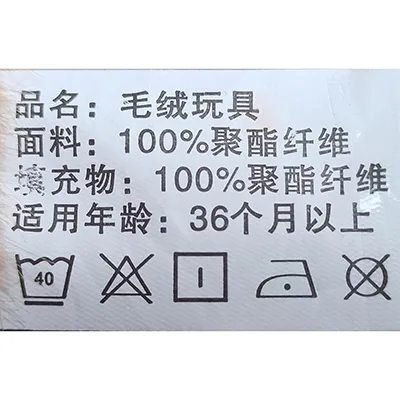 Jouet doux brun en forme de chien avec un hochet autour du cou.