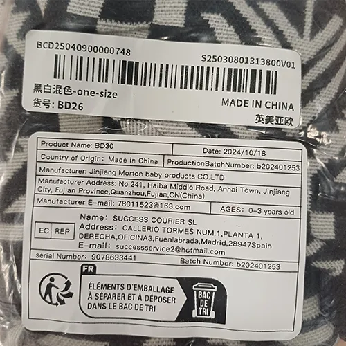 Porte-bébé en tissu blanc avec des motifs noirs et une attache en plastique.