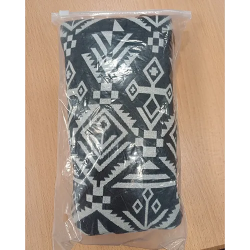 Porte-bébé en tissu blanc avec des motifs noirs et une attache en plastique.