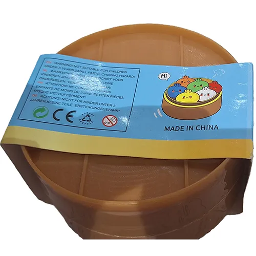 Pressez le jouet en forme de boulette chinoise dans un récipient en plastique fait pour ressembler à un vapeur de bambou.