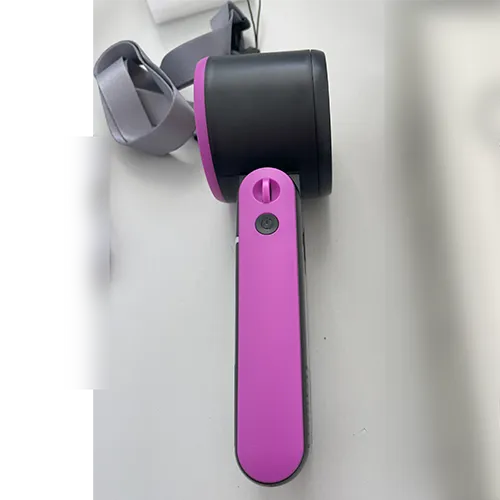Ventilateur pliable portable rechargeable avec un boîtier en plastique noir et rose, vendu avec un câble de chargement USB et une sangle de poignet.