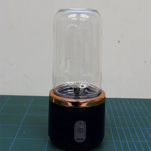 Presse-agrumes portable composée d'un cylindre en plastique, de l'unité de coupe et d'un câble USB.