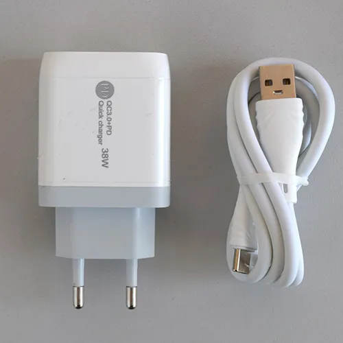 Chargeur USB blanc avec un port USB-A et un port USB-C, fourni avec un câble de connexion USB séparé. Entrée : 100-240V, 50-60Hz, 0.35A. Réalisation : 5V/3A, 9V/2A, 12V/1.5A.