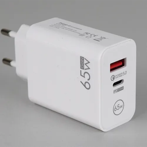 Chargeur USB blanc avec un port USB-A et un port USB-C, intégré à une prise secteur. Entrée : 100-240 V, 50/60 Hz, 0,5 A. Sortie: 9 V/7.2 A, 12 V/5.4 A, 20 V/3.25 A.