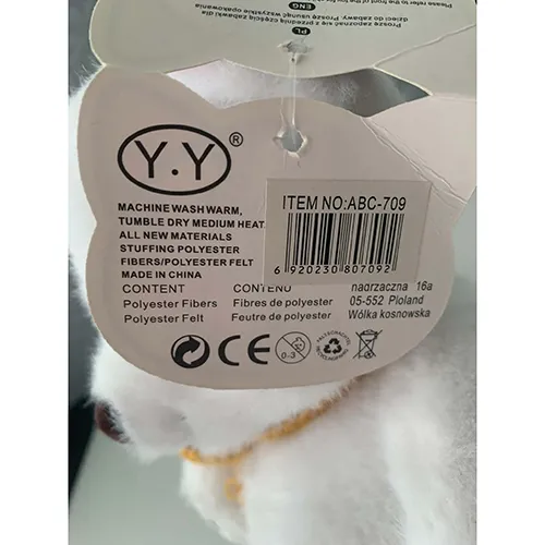 Ours en peluche blanc doux fait de matière textile et rempli d'une farce douce. Il a un nez brun, des marques de pattes décoratives et un foulard tricoté jaune attaché autour de son cou.